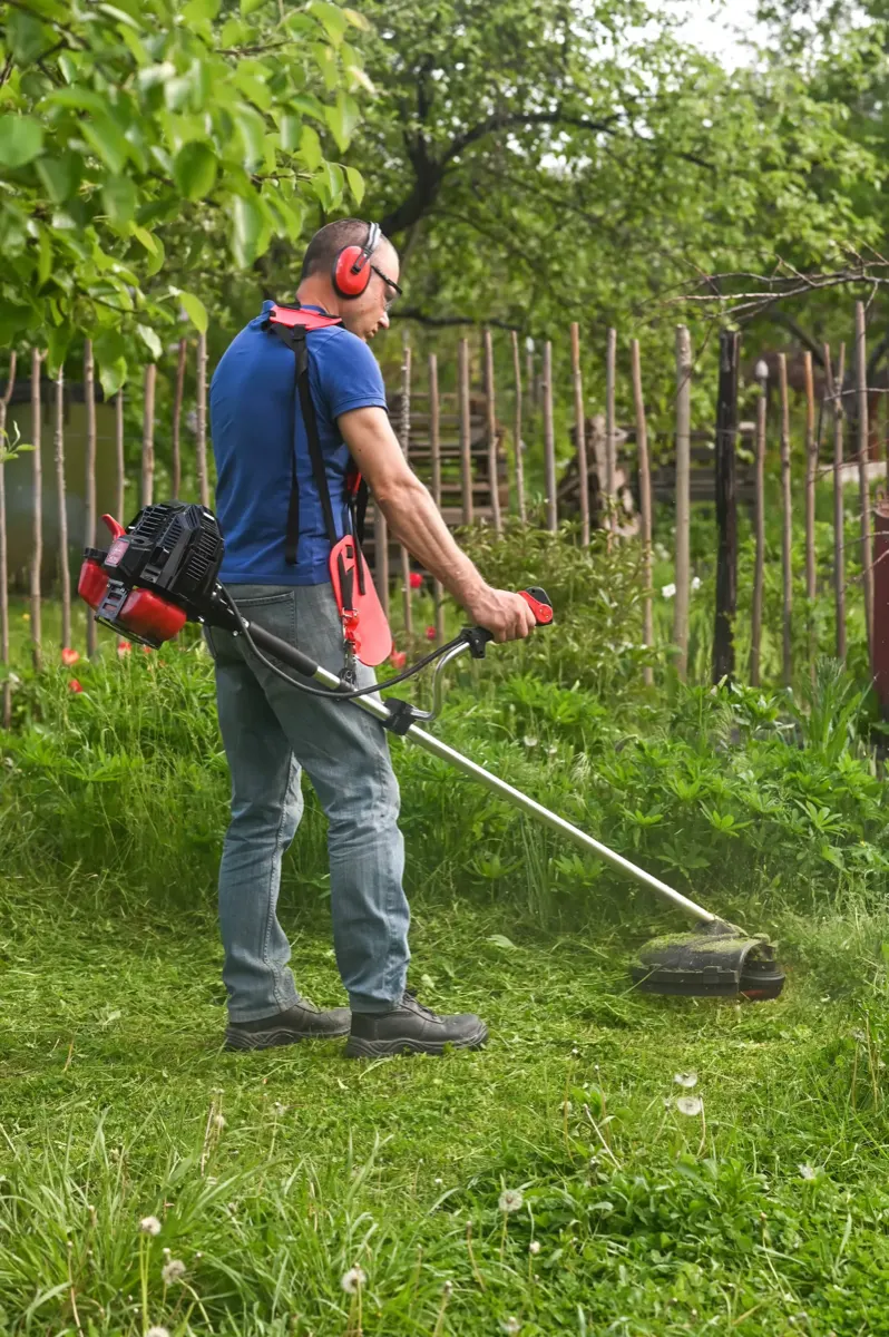 worker mows the lawn grass with a lawn mower